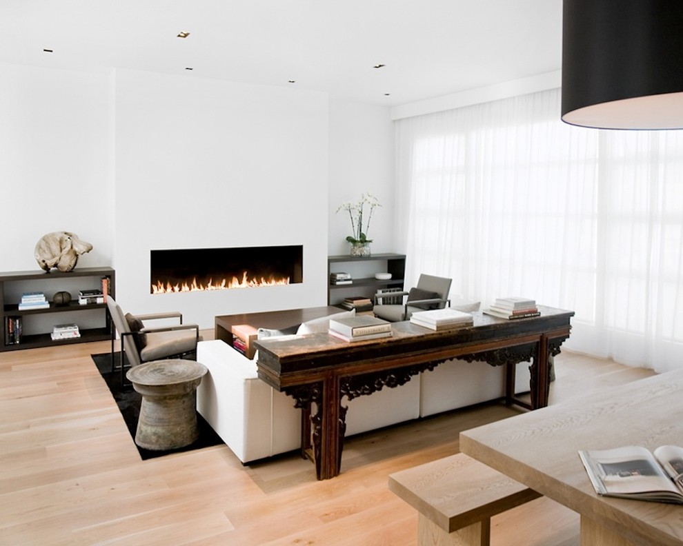 Пример оригинального дизайна: гостиная комната в стиле модернизм с белыми стенами, горизонтальным камином и ковром на полу