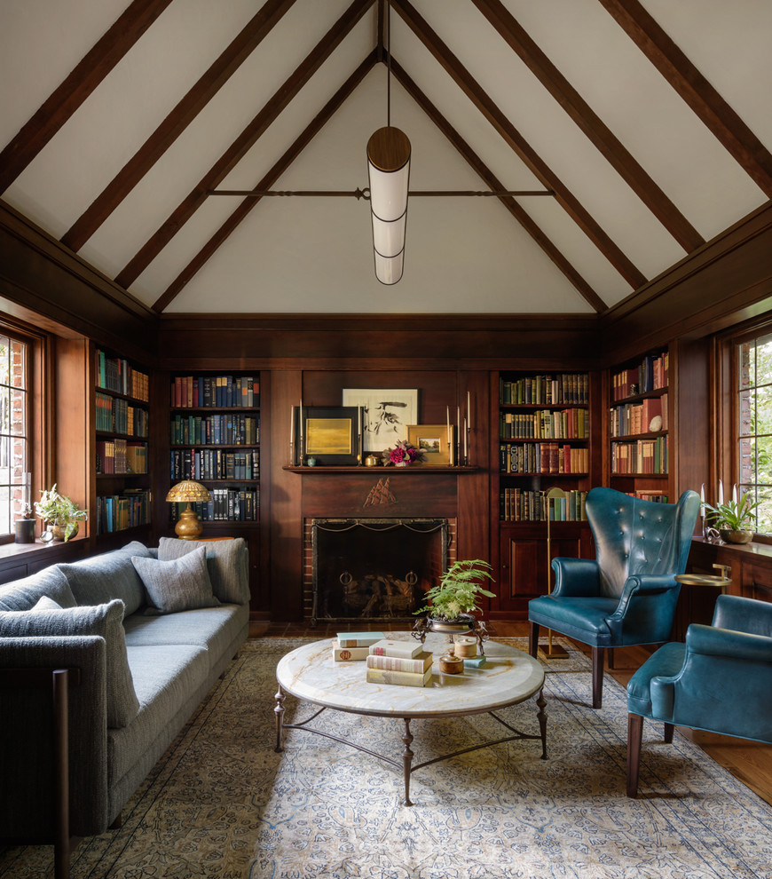 Inspiration för ett vintage vardagsrum, med ett bibliotek, mörkt trägolv, en standard öppen spis, en spiselkrans i tegelsten och brunt golv
