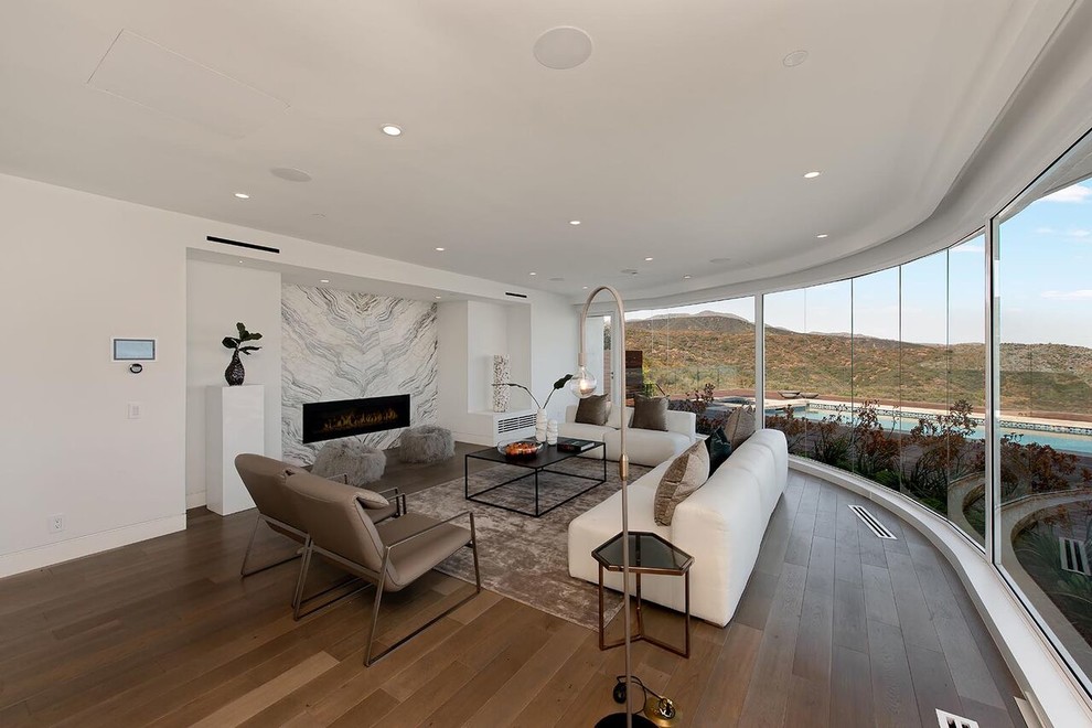 Photo of a large modern formal open plan living room in Los Angeles with white walls, medium hardwood flooring and brown floors.