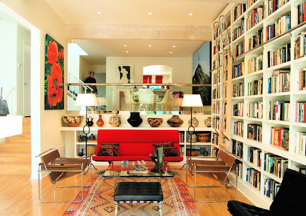 Idee per un soggiorno moderno di medie dimensioni e aperto con libreria, parquet chiaro, pareti bianche e TV a parete