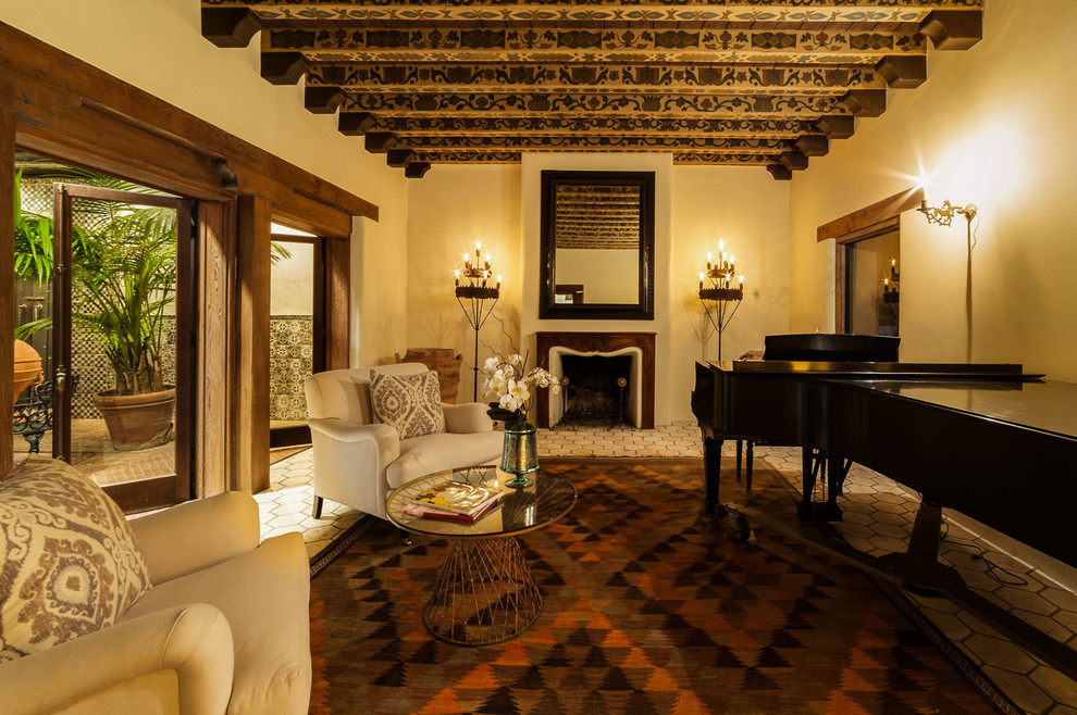 Großes, Offenes, Fernseherloses Mediterranes Musikzimmer mit beiger Wandfarbe, Kamin und Kaminumrandung aus Holz in Los Angeles