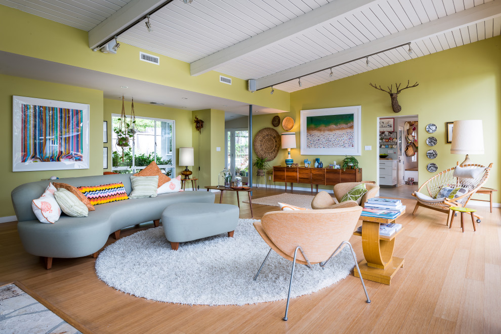 Repräsentatives, Offenes Mid-Century Wohnzimmer ohne Kamin mit grüner Wandfarbe, braunem Holzboden, Holzdielendecke und gewölbter Decke in Los Angeles