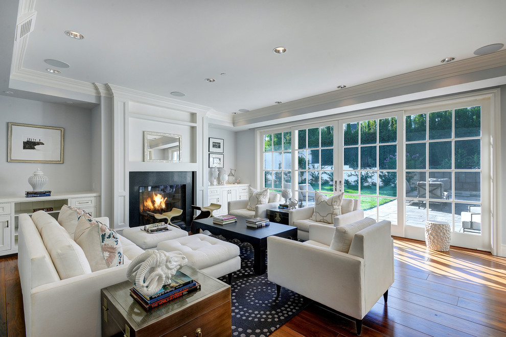 Стильный дизайн: парадная, открытая гостиная комната в классическом стиле с серыми стенами, паркетным полом среднего тона и стандартным камином без телевизора - последний тренд