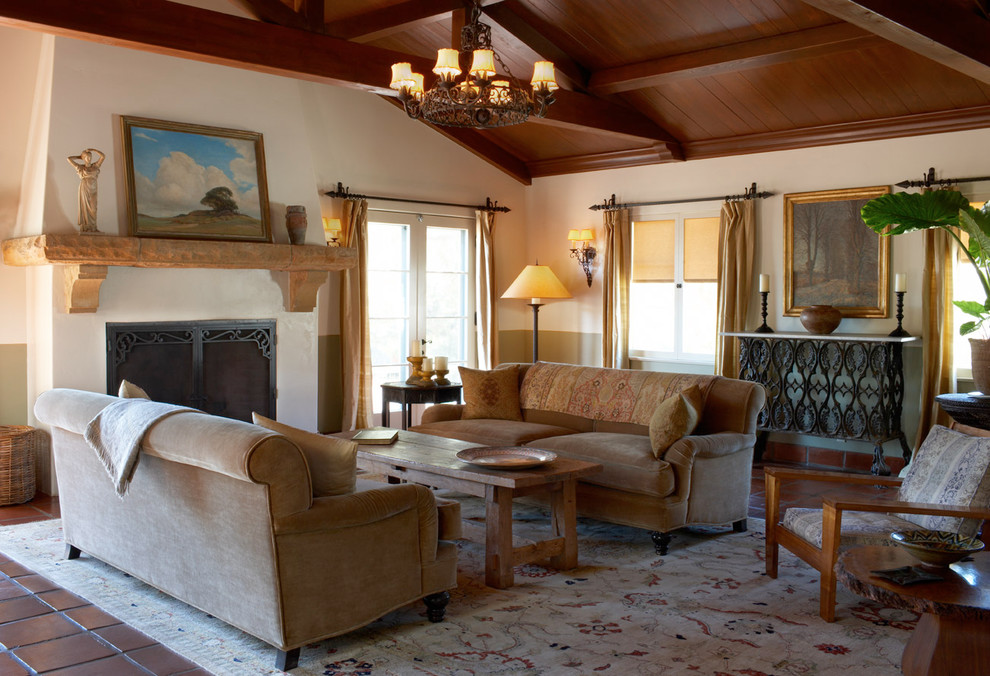 Exemple d'un grand salon méditerranéen ouvert avec une salle de réception, un mur beige, tomettes au sol, une cheminée d'angle, un manteau de cheminée en pierre, aucun téléviseur et un sol marron.