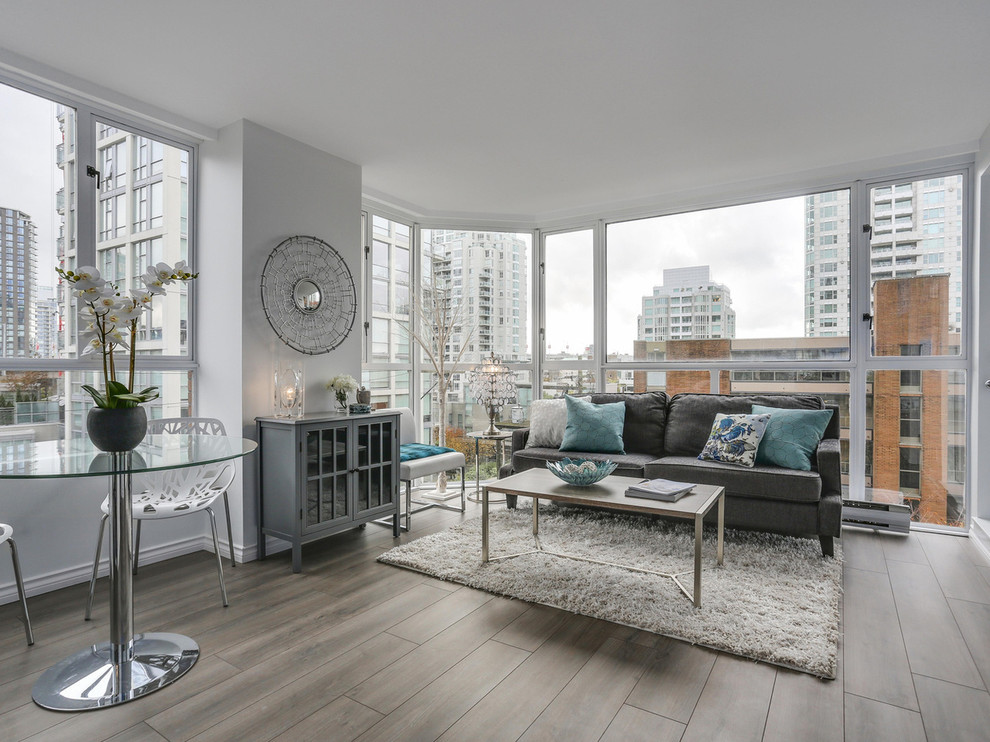 This is an example of a medium sized contemporary formal and grey and teal enclosed living room in Vancouver with white walls and slate flooring.