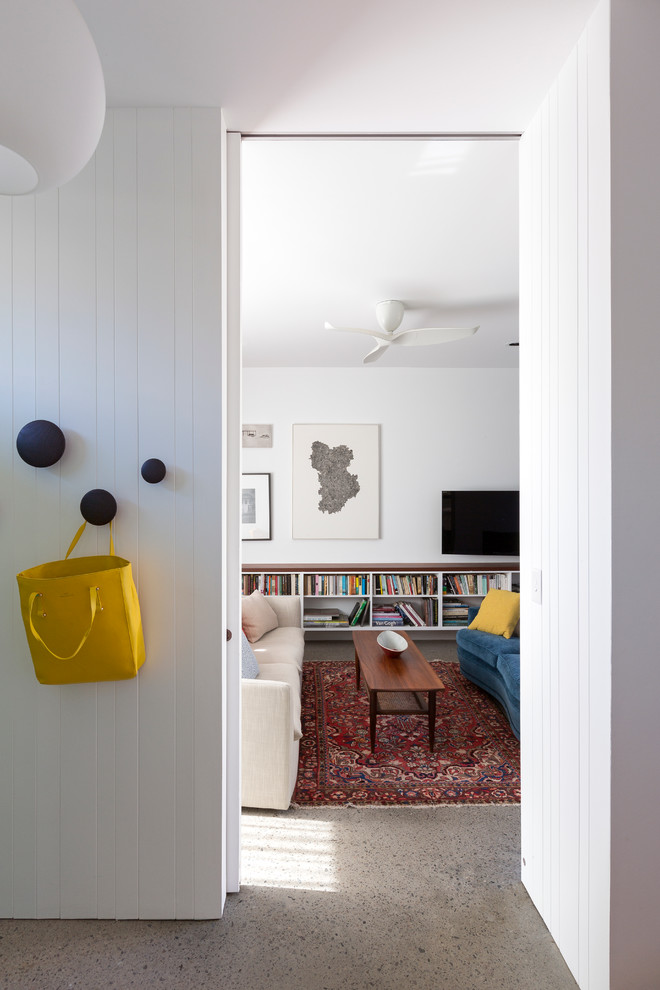 Idéer för ett mellanstort modernt separat vardagsrum, med vita väggar, betonggolv och en väggmonterad TV