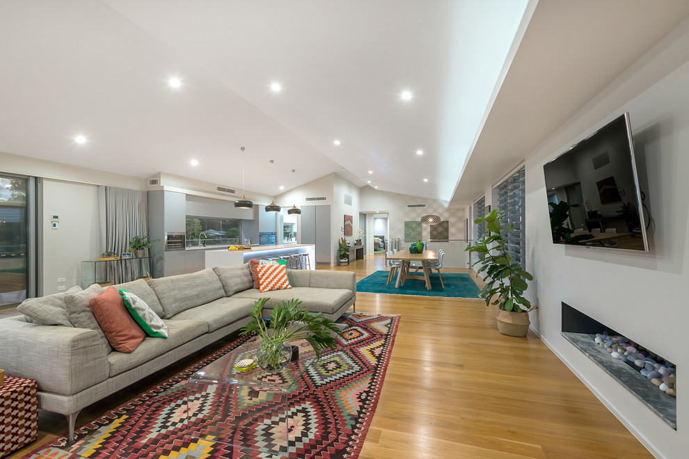 Mid-sized trendy open concept brown floor and medium tone wood floor living room photo in Brisbane with a wall-mounted tv, gray walls and a ribbon fireplace