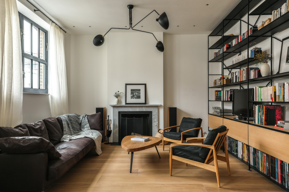 This is an example of a medium sized contemporary formal enclosed living room in London with white walls, medium hardwood flooring, a standard fireplace, a tiled fireplace surround, no tv and beige floors.
