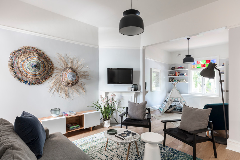 Стильный дизайн: изолированная гостиная комната среднего размера в классическом стиле с синими стенами, паркетным полом среднего тона, угловым камином, фасадом камина из штукатурки и телевизором на стене - последний тренд