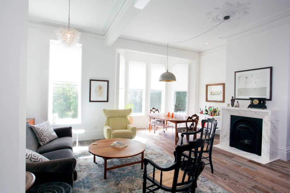 Foto på ett funkis allrum med öppen planlösning, med vita väggar, mellanmörkt trägolv, en standard öppen spis och brunt golv