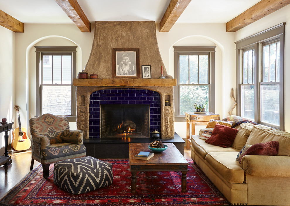 This is an example of a medium sized mediterranean living room in Nashville with white walls, a standard fireplace and a tiled fireplace surround.