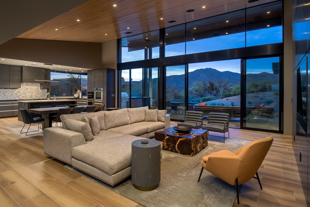 Example of a mid-sized trendy open concept porcelain tile and brown floor living room design in Phoenix with multicolored walls and a media wall