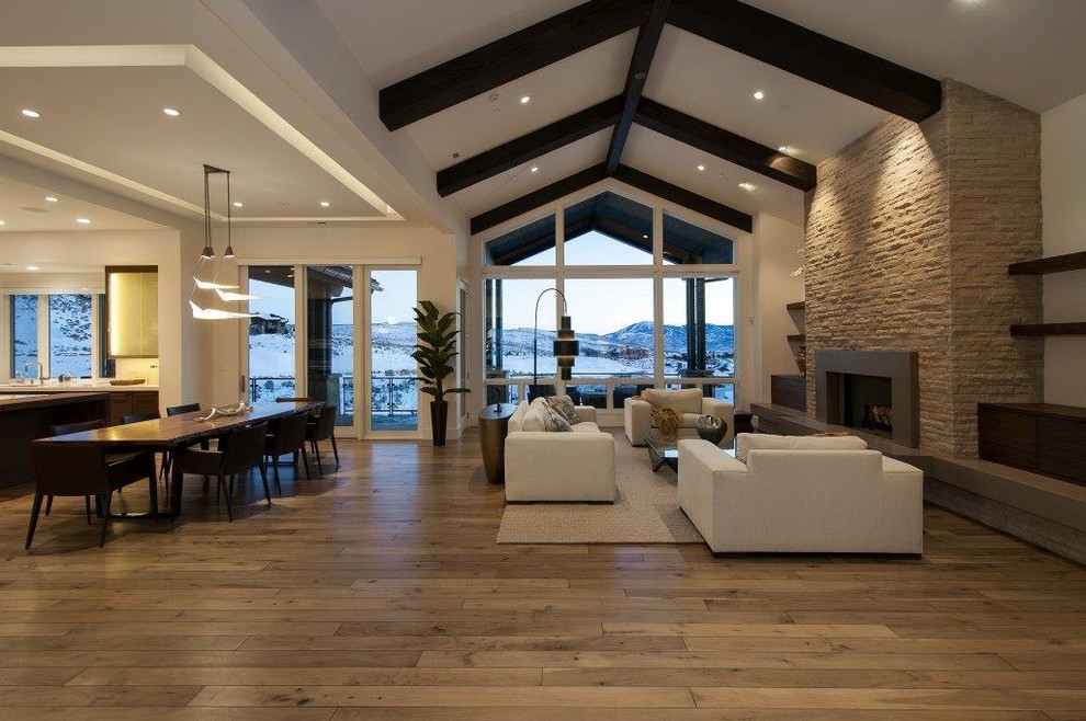 Photo of a large contemporary formal open plan living room in Salt Lake City with white walls, medium hardwood flooring, a standard fireplace, a stone fireplace surround and no tv.