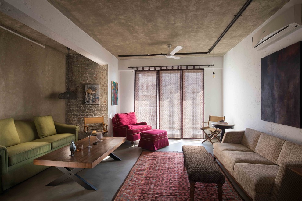 Свежая идея для дизайна: гостиная комната в средиземноморском стиле с белыми стенами, бетонным полом, серым полом и коричневым диваном - отличное фото интерьера