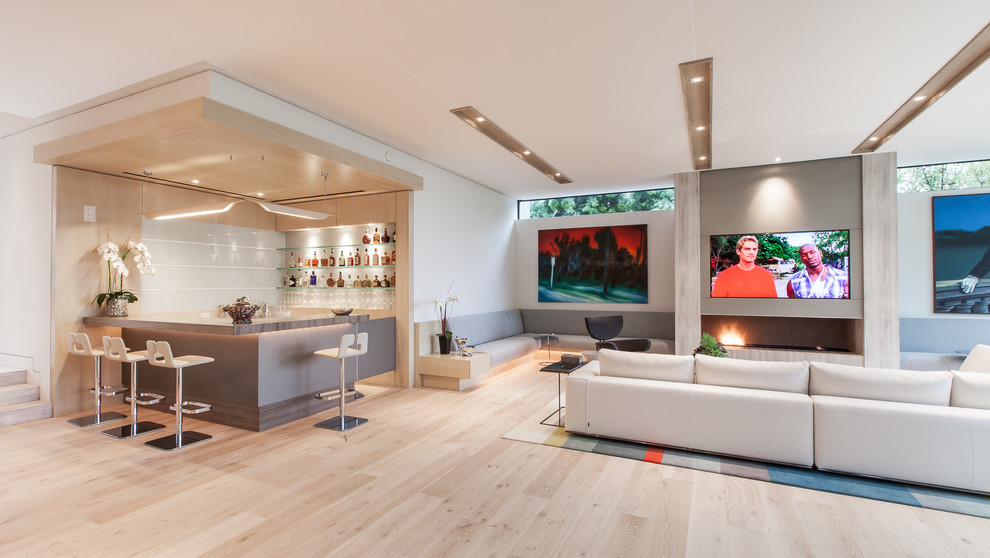 Mittelgroßes, Repräsentatives, Offenes Modernes Wohnzimmer mit beiger Wandfarbe, braunem Holzboden, Kamin, Kaminumrandung aus Stein und verstecktem TV in Austin