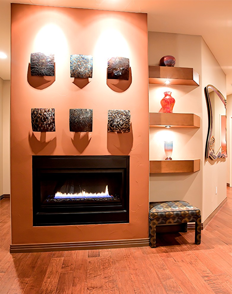 他の地域にある高級な広いコンテンポラリースタイルのおしゃれなLDK (茶色い壁、無垢フローリング、横長型暖炉、漆喰の暖炉まわり、壁掛け型テレビ、茶色い床) の写真