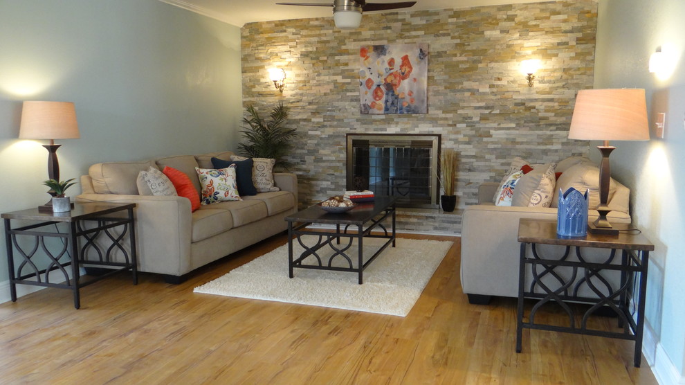 На фото: открытая гостиная комната среднего размера в стиле неоклассика (современная классика) с синими стенами, светлым паркетным полом, стандартным камином, фасадом камина из камня и телевизором на стене с