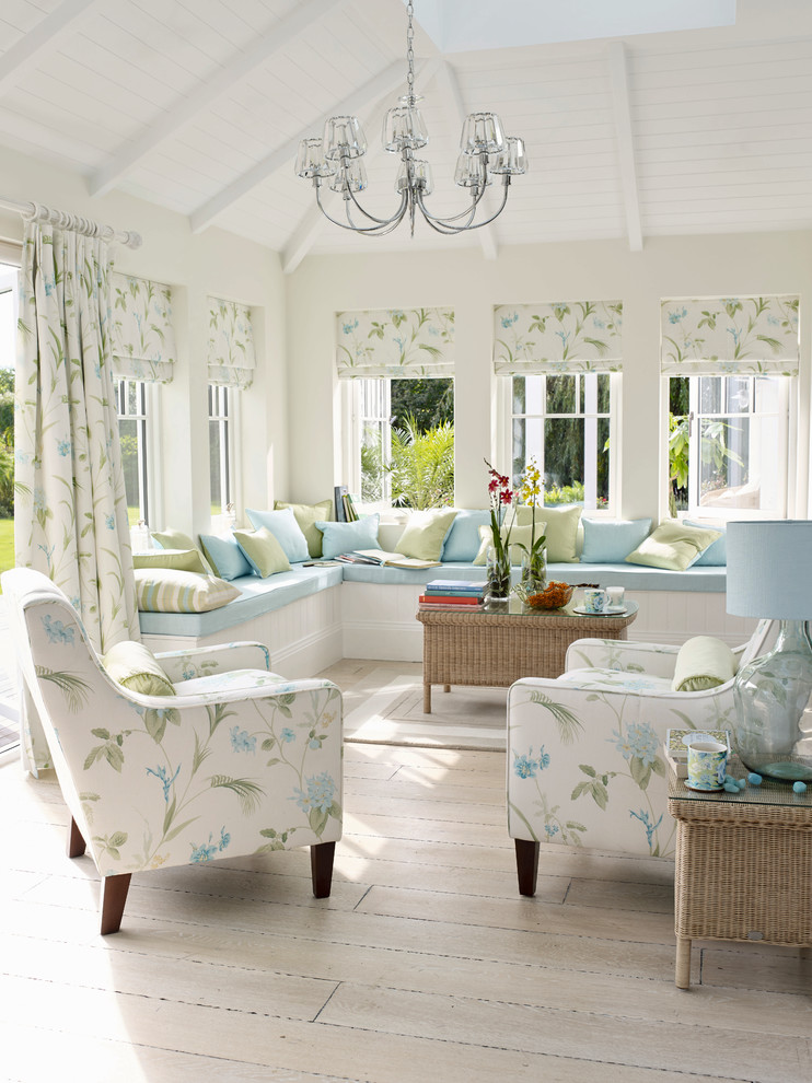 Esempio di un soggiorno stile marinaro di medie dimensioni e aperto con pareti bianche e parquet chiaro