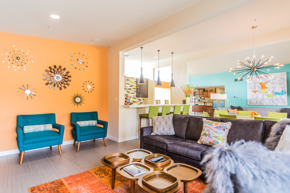 На фото: открытая гостиная комната среднего размера в стиле ретро с оранжевыми стенами, полом из керамической плитки и серым полом
