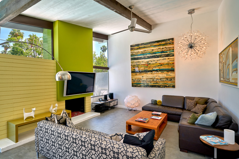 Foto di un soggiorno minimalista aperto con TV a parete, pareti grigie, camino classico, cornice del camino in mattoni e pavimento grigio