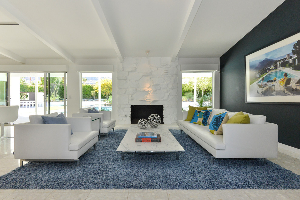 Immagine di un soggiorno minimalista aperto con sala formale, pareti nere, camino classico, cornice del camino in pietra e nessuna TV