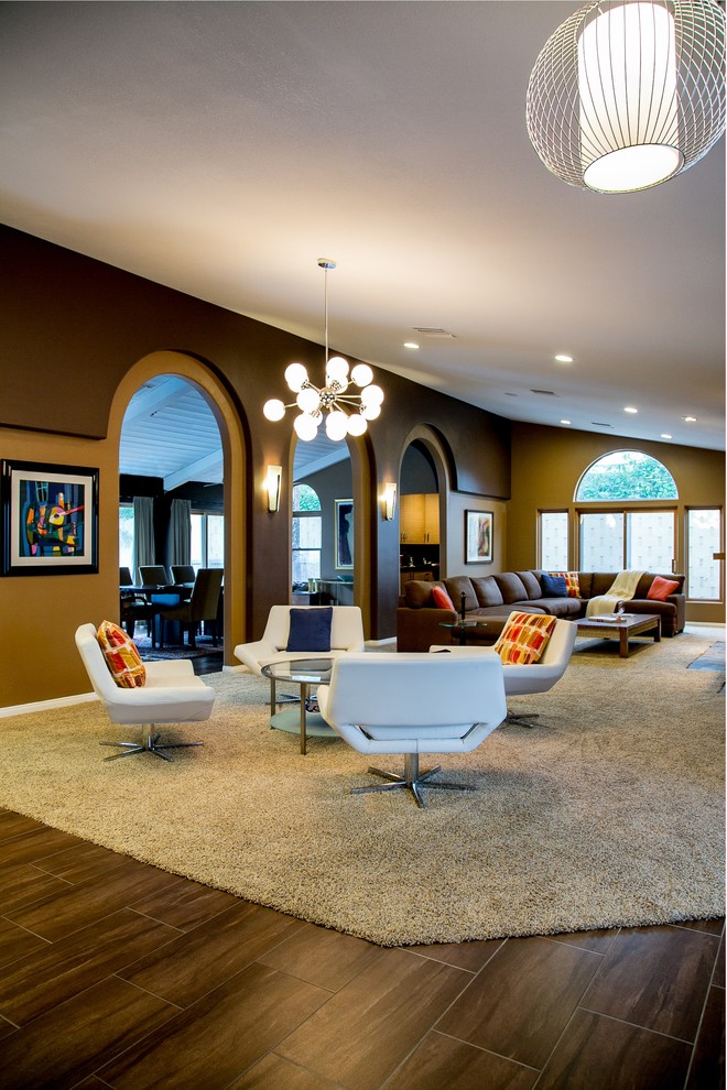 Esempio di un grande soggiorno moderno aperto con pareti marroni, moquette, camino classico, cornice del camino piastrellata, parete attrezzata e pavimento beige