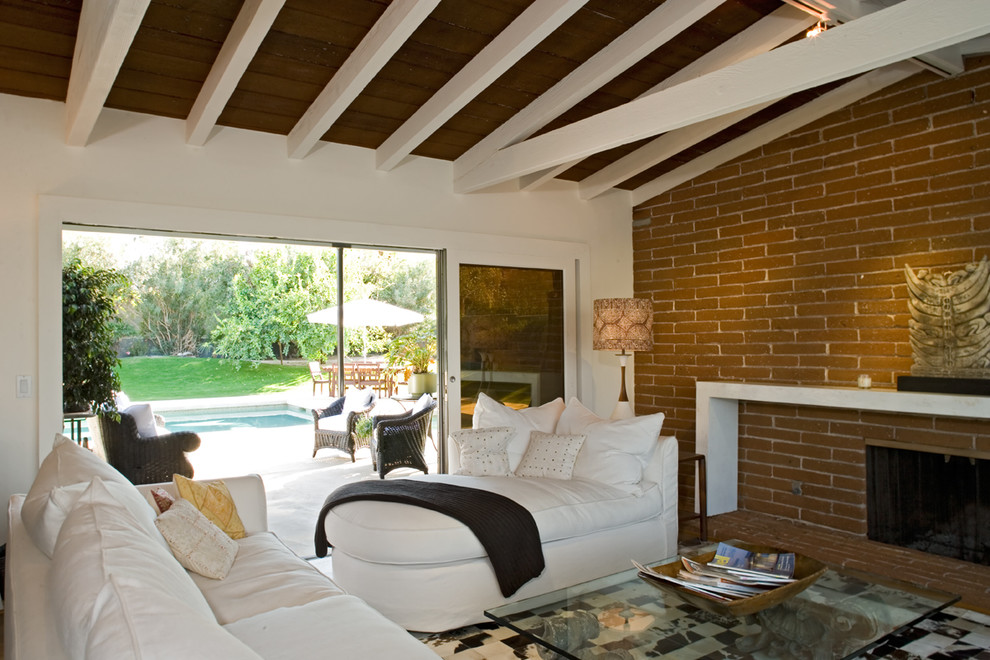 На фото: гостиная комната в современном стиле с стандартным камином и фасадом камина из кирпича