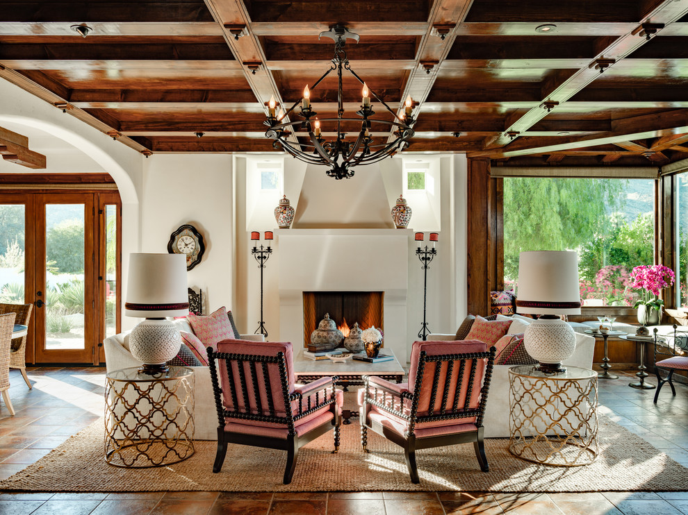 Источник вдохновения для домашнего уюта: гостиная комната в средиземноморском стиле с белыми стенами, стандартным камином и коричневым полом