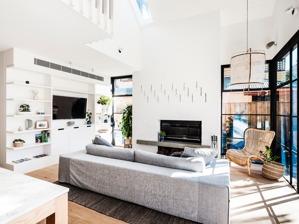 Mittelgroßes, Offenes Modernes Wohnzimmer mit weißer Wandfarbe, braunem Holzboden, Kamin, Kaminumrandung aus Backstein, Multimediawand und braunem Boden in Sydney