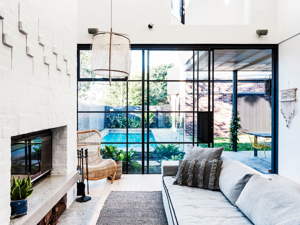 Mittelgroßes, Offenes Modernes Wohnzimmer mit weißer Wandfarbe, braunem Holzboden, Kamin, Kaminumrandung aus Backstein, Multimediawand und braunem Boden in Sydney