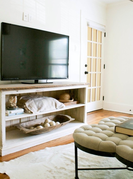 Cette image montre un petit salon chalet fermé avec un mur blanc, un sol en bois brun et un téléviseur indépendant.