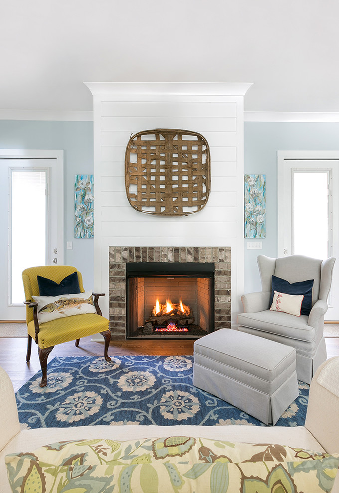 Inspiration for a mid-sized timeless open concept medium tone wood floor living room remodel in Charleston with blue walls, a standard fireplace and a brick fireplace