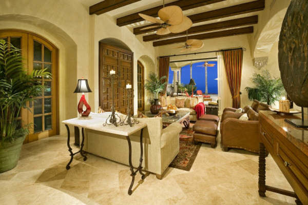 Idee per un grande soggiorno tropicale chiuso con sala formale, pareti beige, pavimento in travertino e TV nascosta