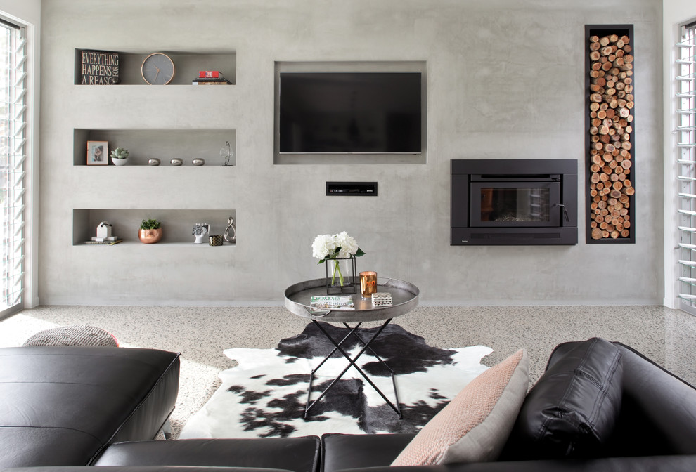 Ispirazione per un soggiorno minimalista di medie dimensioni e aperto con pareti grigie, pavimento in cemento, cornice del camino in cemento, parete attrezzata e camino sospeso