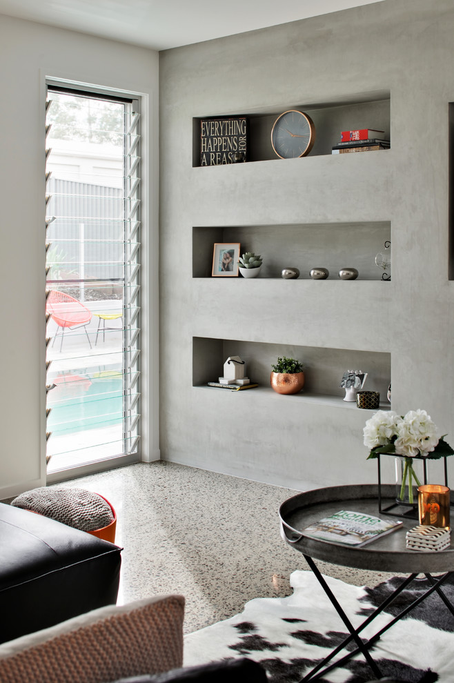 На фото: открытая гостиная комната среднего размера в стиле модернизм с серыми стенами, бетонным полом, фасадом камина из бетона, мультимедийным центром и подвесным камином с