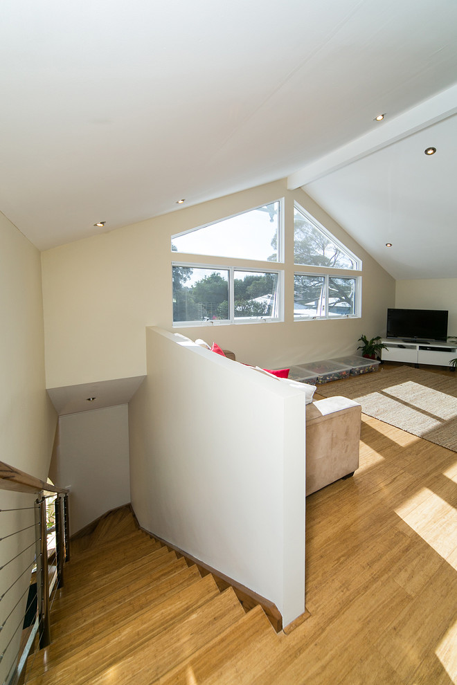 На фото: изолированная гостиная комната среднего размера в стиле модернизм с полом из бамбука и отдельно стоящим телевизором