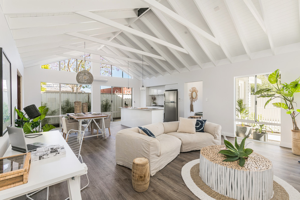 Immagine di un soggiorno costiero aperto con pareti bianche, pavimento in legno massello medio e pavimento marrone