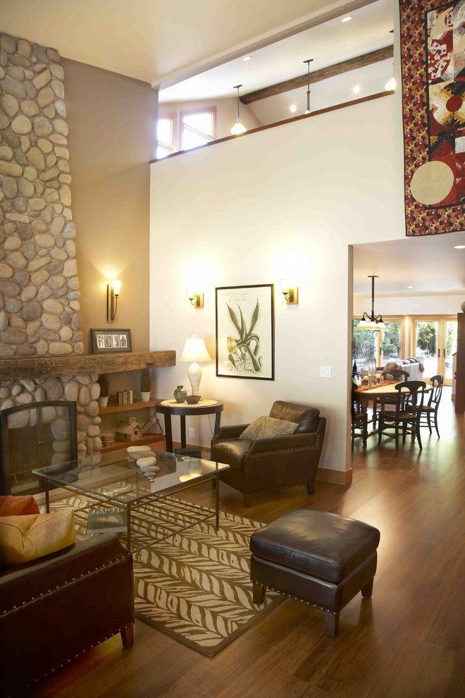 Cette photo montre un salon montagne ouvert et de taille moyenne avec un mur marron, parquet en bambou, une cheminée standard, un manteau de cheminée en pierre et un sol marron.