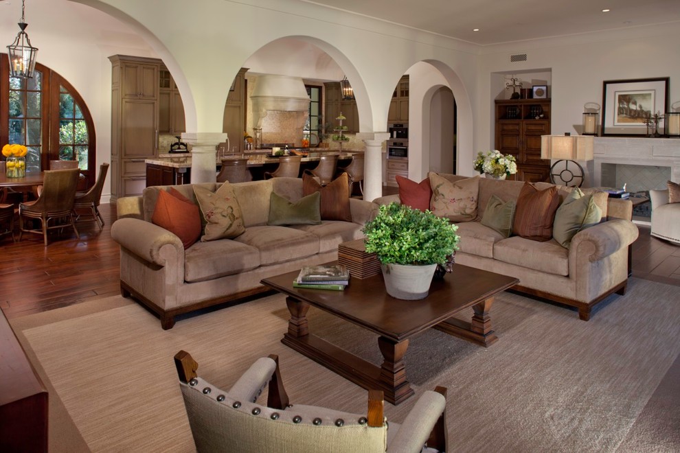 Offenes Mediterranes Wohnzimmer mit beiger Wandfarbe und dunklem Holzboden in Los Angeles