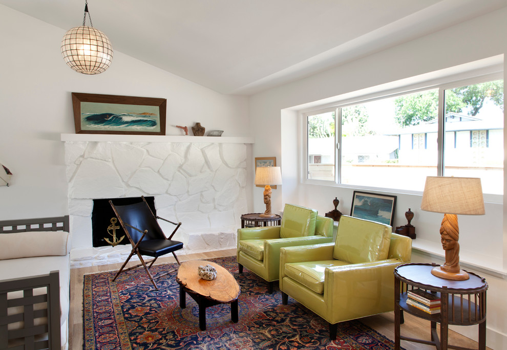 На фото: гостиная комната в стиле ретро с белыми стенами, паркетным полом среднего тона, стандартным камином и фасадом камина из камня с
