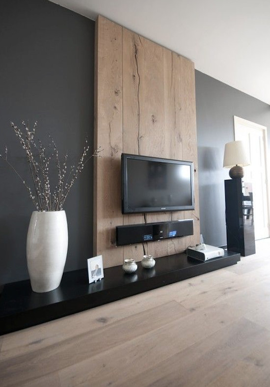 Diseño de salón para visitas abierto contemporáneo grande con paredes negras, suelo de madera clara y televisor colgado en la pared