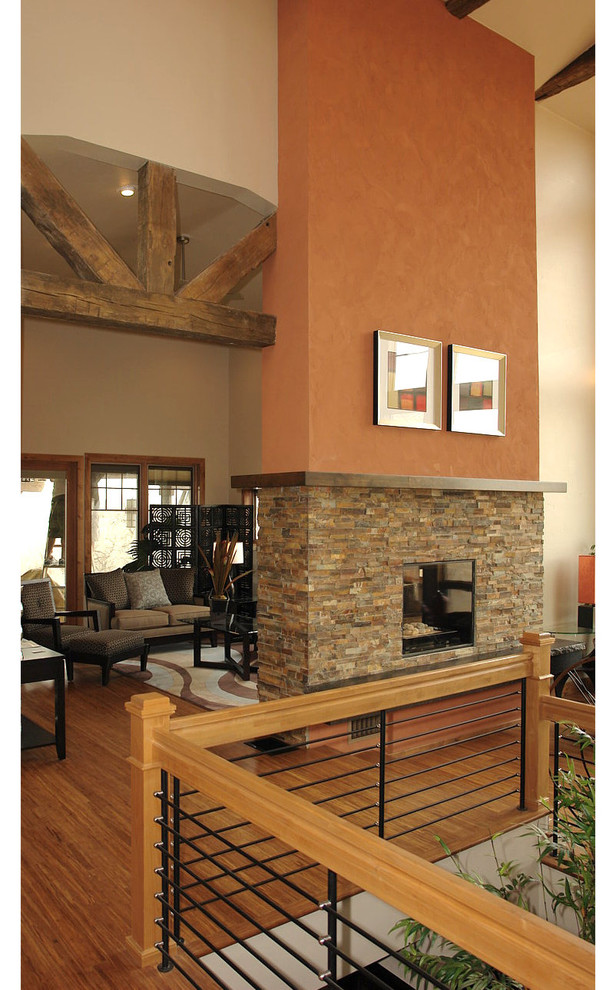 Aménagement d'un salon contemporain de taille moyenne et ouvert avec un mur multicolore, parquet foncé, une cheminée double-face, un manteau de cheminée en pierre et un sol marron.