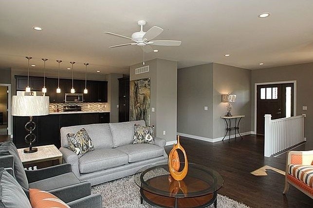 Medium sized contemporary open plan living room in Cedar Rapids with grey walls, dark hardwood flooring, no fireplace, a wall mounted tv and feature lighting.