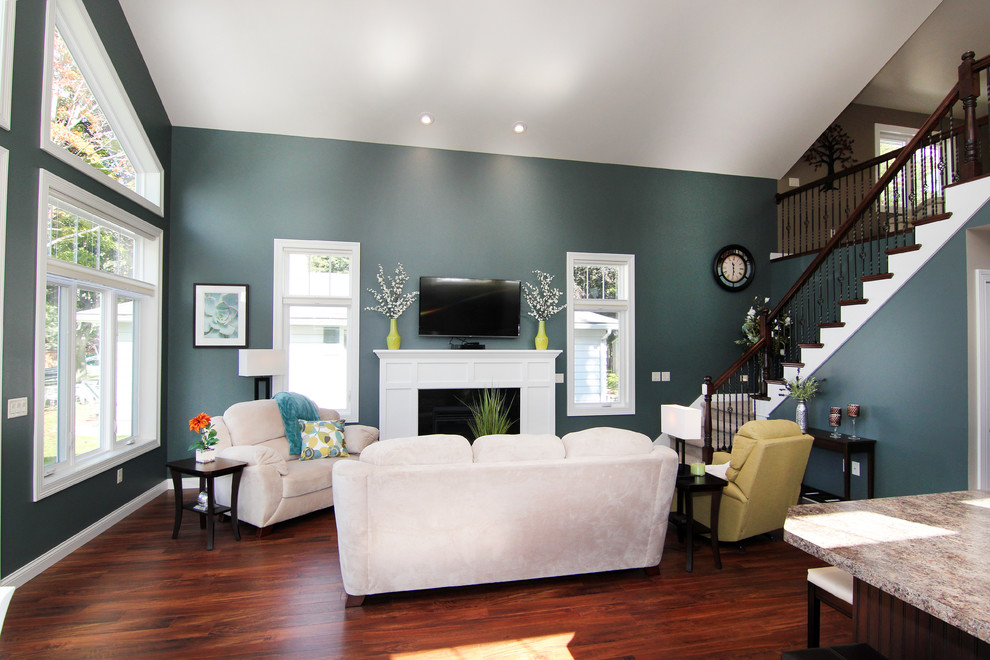 Esempio di un soggiorno minimalista aperto con pavimento in vinile, camino classico, cornice del camino in legno e TV a parete