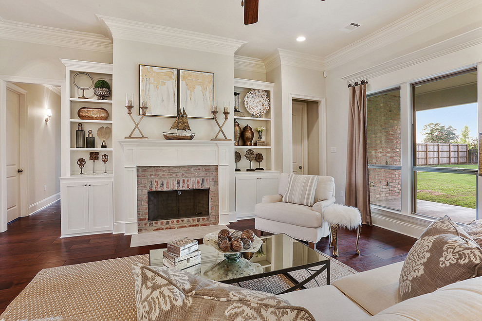 Mid-sized elegant open concept medium tone wood floor living room photo in New Orleans with beige walls, a standard fireplace and a brick fireplace