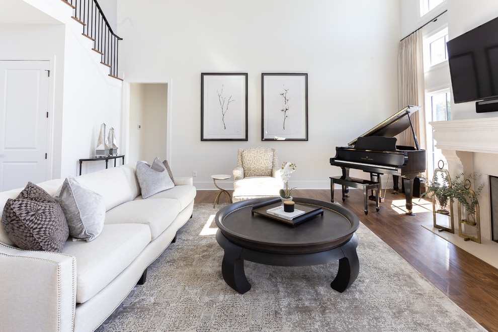 Immagine di un soggiorno chic con pareti bianche, pavimento in legno massello medio, camino classico, TV a parete e pavimento marrone