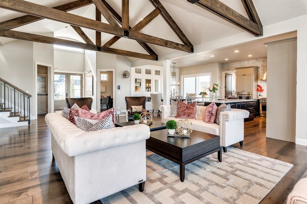 Inspiration for a large traditional open plan living room in Boise with beige walls, medium hardwood flooring, a two-sided fireplace, a stone fireplace surround, no tv and brown floors.