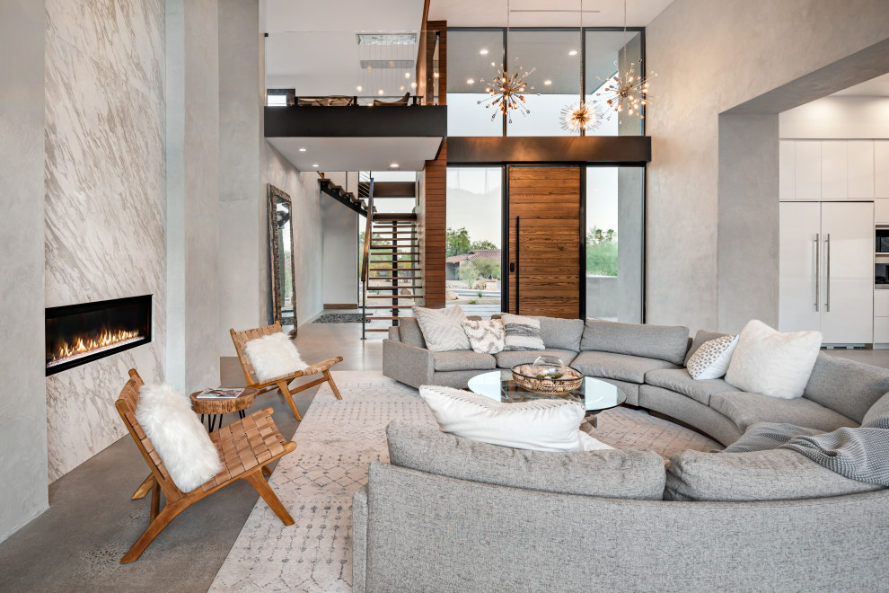 На фото: парадная, открытая гостиная комната в современном стиле с серыми стенами, бетонным полом, горизонтальным камином и фасадом камина из камня без телевизора