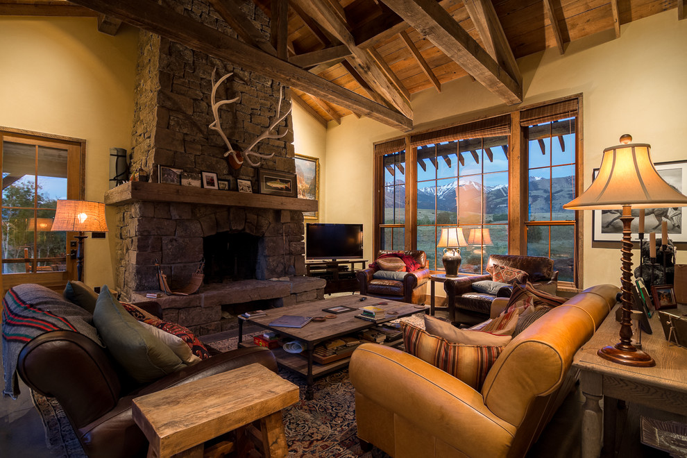 Photo of a large rustic enclosed living room in Other with white walls, dark hardwood flooring, a standard fireplace, a stone fireplace surround, a freestanding tv and brown floors.