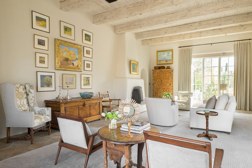 Mediterranean living room in New York with beige walls, a standard fireplace and brown floors.